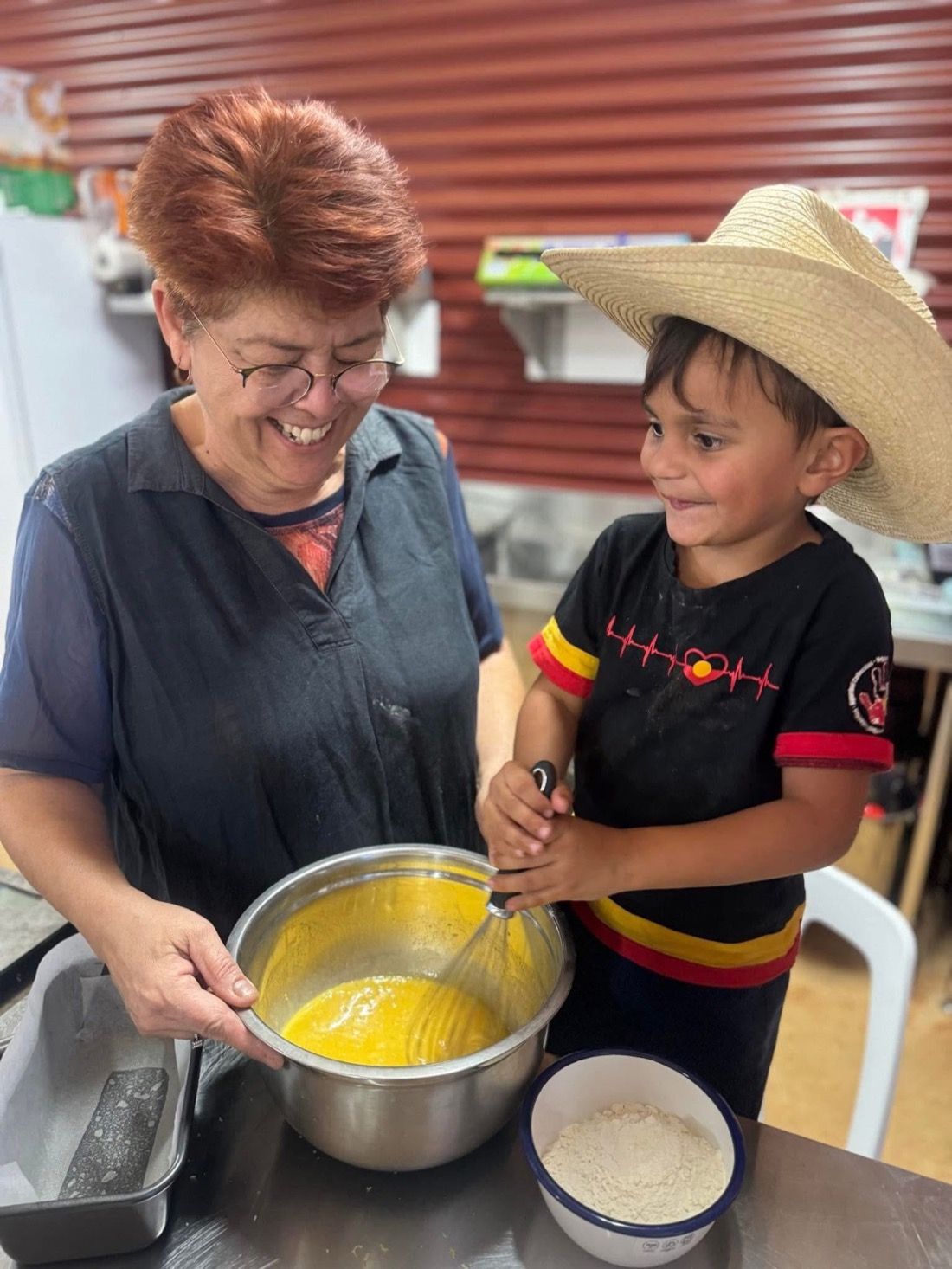 Aunty Donna cooking with a young helper in the kitchen.