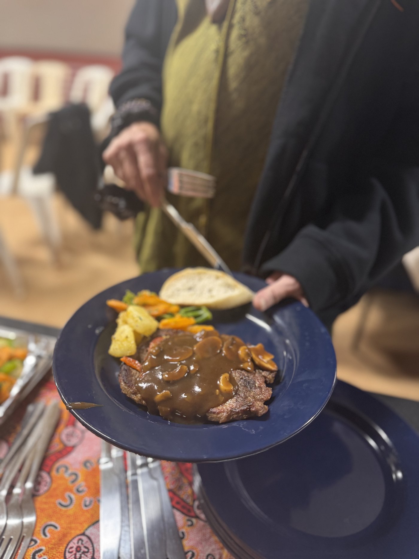 Country Heart Catering community event spread with steak, vegetables and bread on an Aboriginal-design tablecloth.