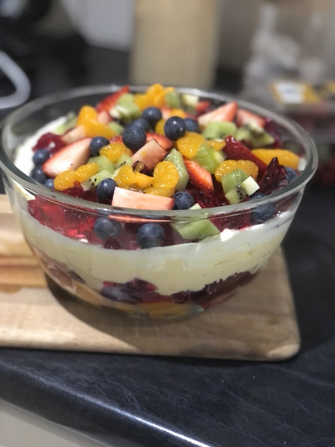 Layered fruit trifle in a glass bowl.