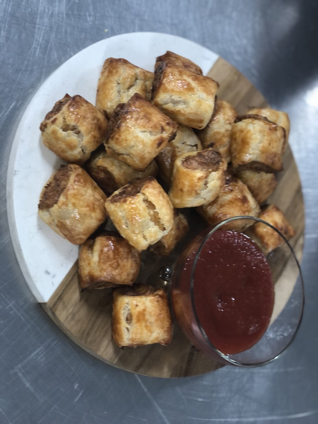 Sausage rolls served with tomato sauce.
