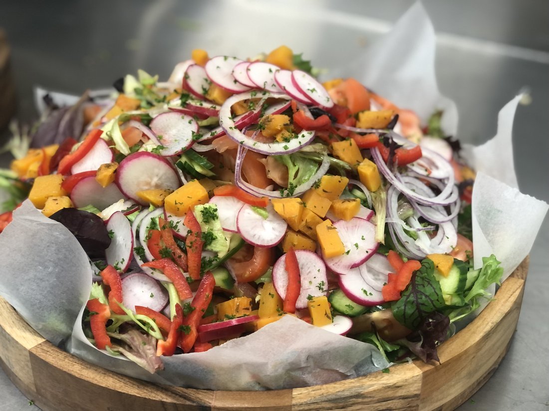 Large mixed garden salad with radishes and onion.