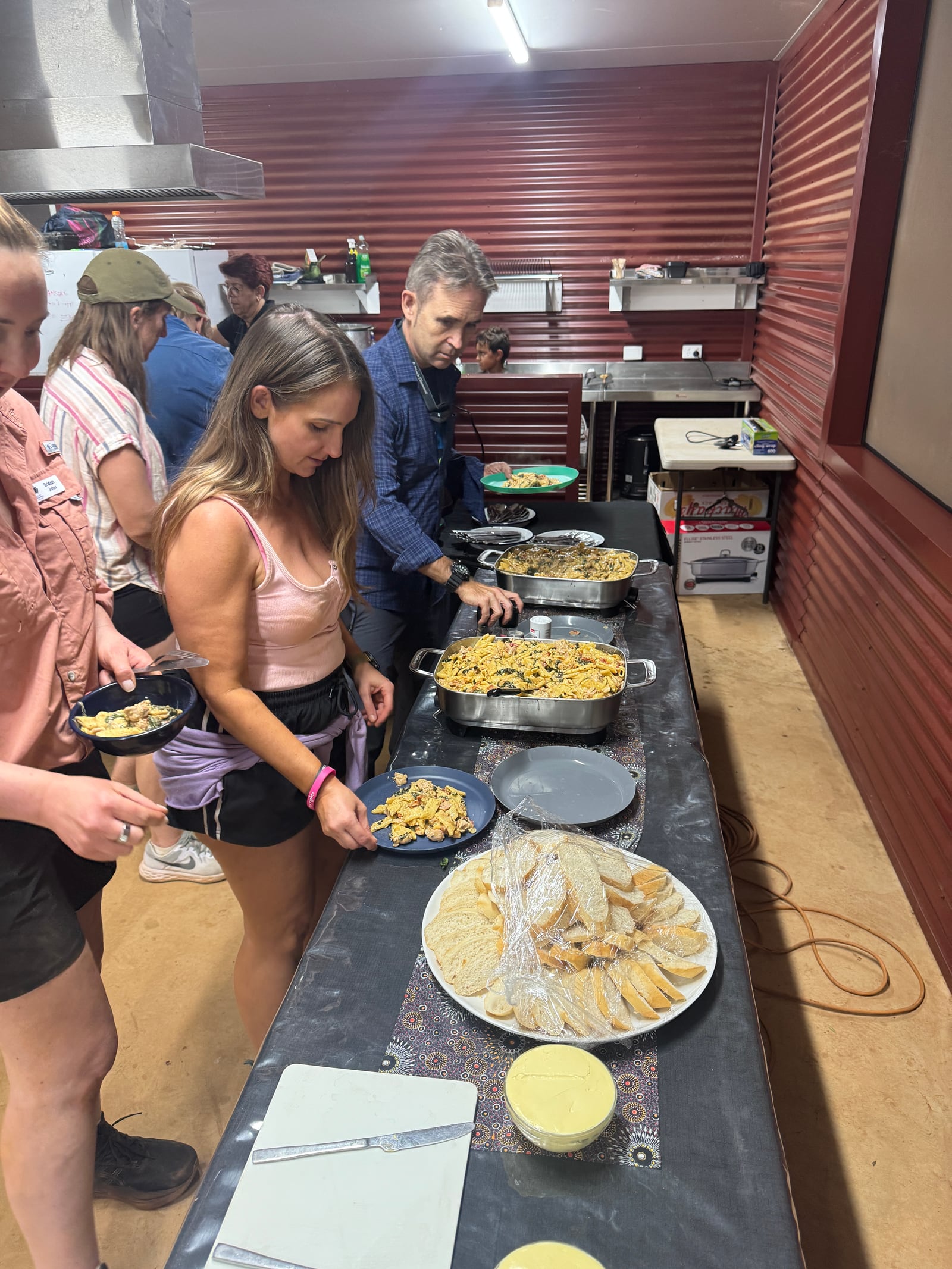 Guests enjoying pasta and salad from a catered buffet.