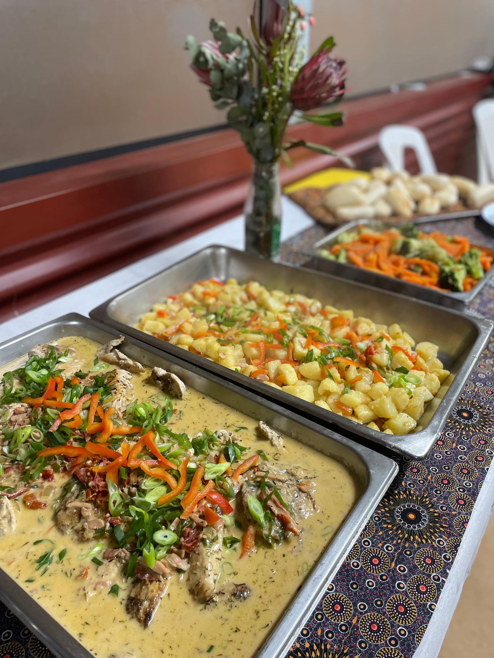 Hot catered dishes set out for a gathering.