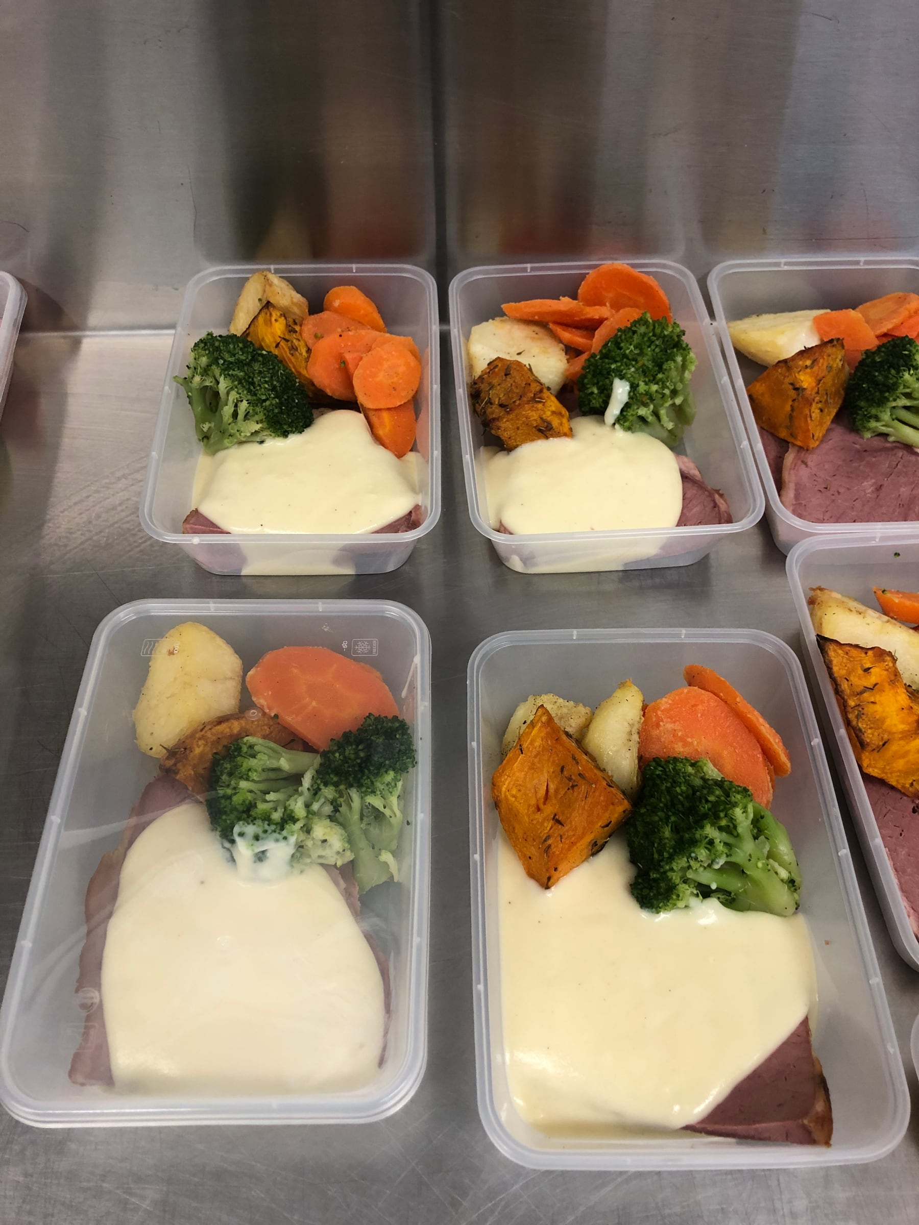 Prepared roast meal containers with vegetables and sauce.