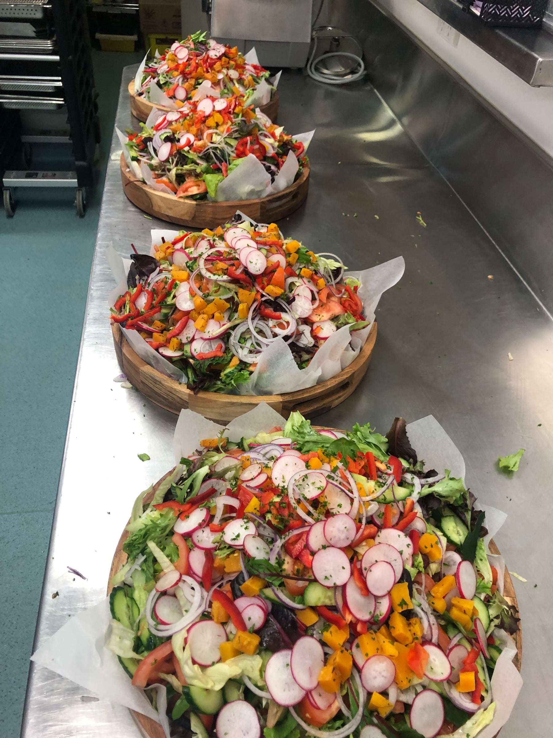 Guests being served hot food and salad at a buffet table.